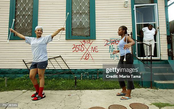 Whitney Kennedy and Joyce Saxton practice baton twirling in preparation for their upcoming high school majorette tryouts in front of rescue worker...