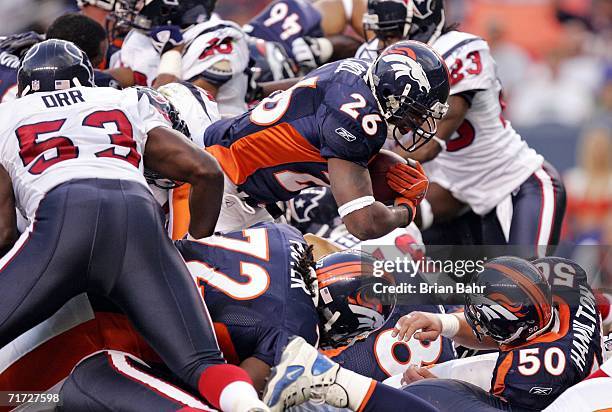 Running back Tatum Bell of the Denver Broncos plows through a pile to score a touchdown against the Houston Texans in the second quarter of a...