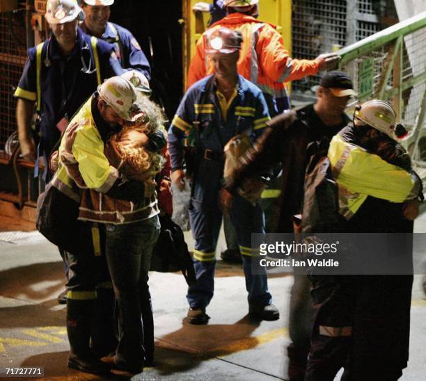 Tasmanian miners Todd Russell and Brant Webb hug family members after being rescued from the Beaconsfield gold mine May 9, 2006 in Beaconsfield,...