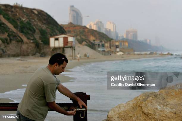 Israeli marine biologist Yaniv Levy opens an access gate that will allow him to begin his early morning search for turtle nests on a Mediterranean...