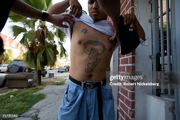 Two Los Angeles police officers question a known Mara Salvatrucha 13 gang member on August 3, 2006 in the Wilshire neighborhood of Los Angeles,...