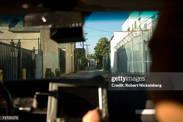 Los Angeles gang police car drives down an alleyway dividing two rival hispanic street gangs on August 4, 2006 in the Rampart neighborhood in Los...