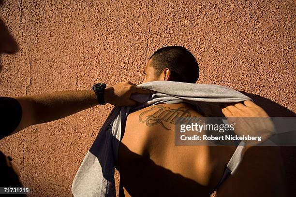 Los Angeles Police Department gang unit officers stop and frisk a known 18th Street gang member on August 5, 2006 in the Rampart district of Los...