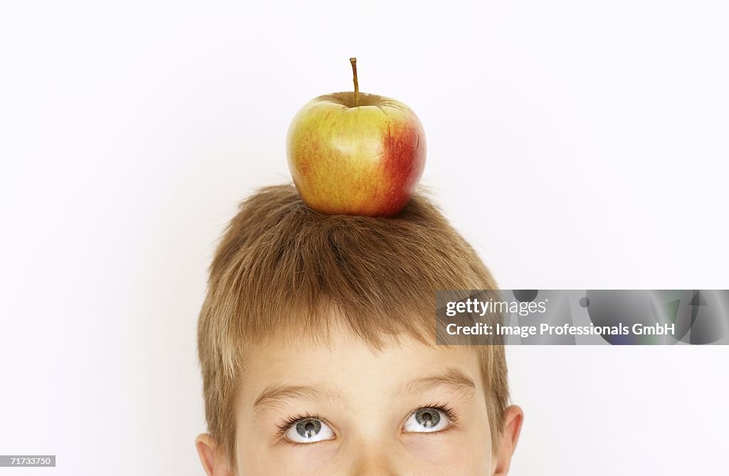 Small boy with apple on his head
