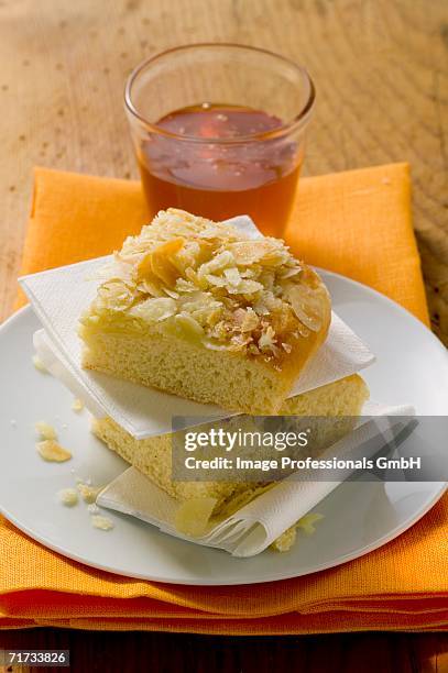 two pieces of bee sting cake on plate in front of honey jar - bee sting stock pictures, royalty-free photos & images