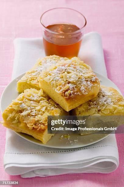 four pieces of bee sting cake on plate in front of glass of honey - bee sting stock pictures, royalty-free photos & images