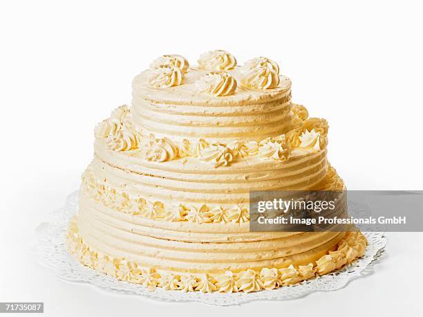 a three-tiered cream cake on white background - cremetorte stock-fotos und bilder