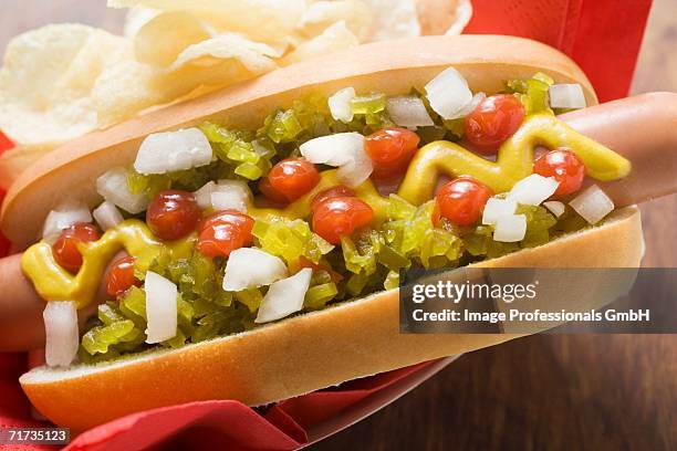 hot dog with relish, mustard, ketchup, onions and crisps - american mustard stock pictures, royalty-free photos & images