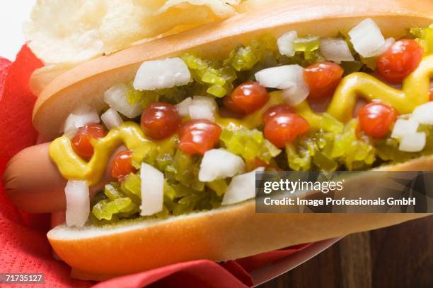 hot dog with relish, mustard, ketchup, onions and crisps - american mustard stock pictures, royalty-free photos & images
