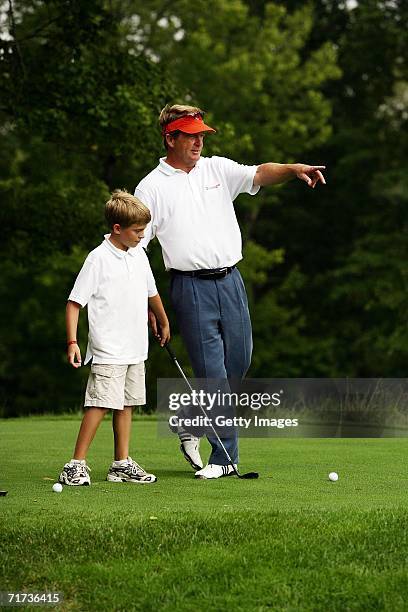 Pro-golfer Fred Funk gives some tips to his son Taylor during the Entertainment Golf Association?s celebrity golf tournament presented by Vonage and...