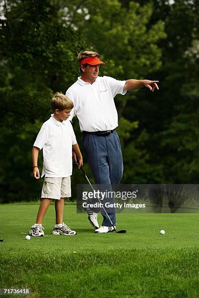Pro-golfer Fred Funk gives some tips to his son Taylor during the Entertainment Golf Association?s celebrity golf tournament presented by Vonage and...