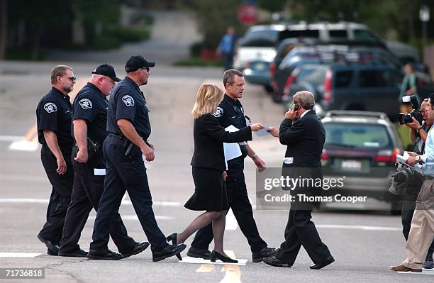 Karen Salaz, spokesperson for the Colorado state court system, approaches the news media with copies of a release announcing that charges against...