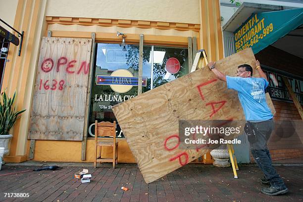 Rogelio Perez places plywood over the windows of his business as he prepares for the approaching Tropical Storm Ernesto that is threatening South...