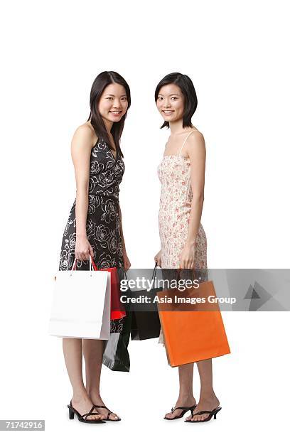 two young women carrying shopping bags - singapore shopping family stock pictures, royalty-free photos & images