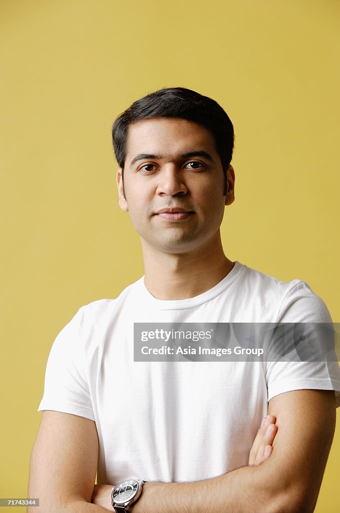 Man standing, arms crossed, looking at camera