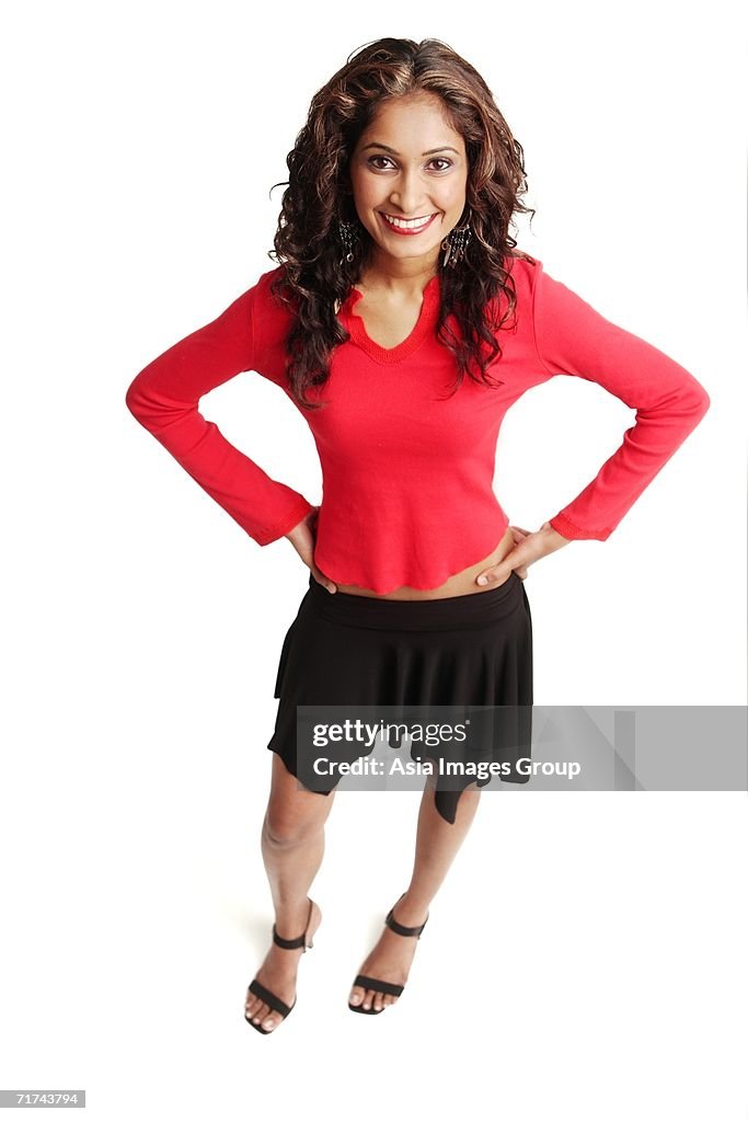 Woman standing, looking at camera, hands on hips