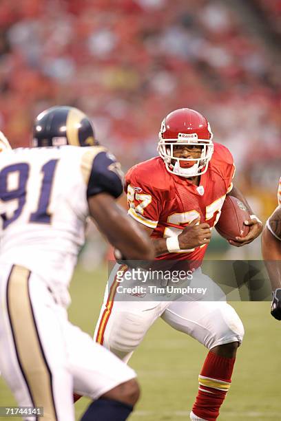 Running back Larry Johnson of the Kansas City Chiefs evades left defensive end Leonard Little of the St. Louis Rams during the preseason game on...