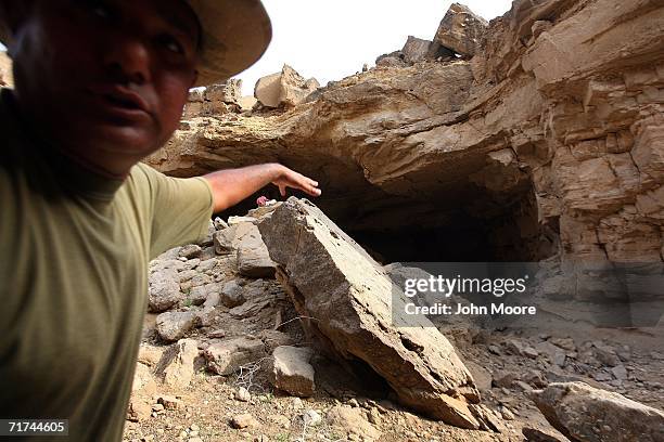 Pakistani officer shows a collapsed cave where the army says that the body of Baloch rebel leader Nawab Akbar Bugti lies beneath the rubble in the...