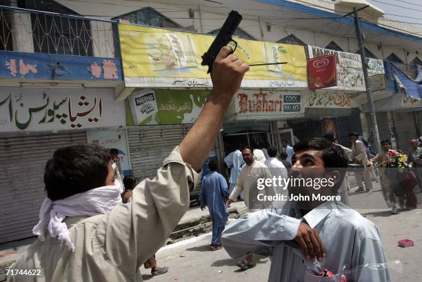 Baloch rioter points a pistol in the air during a violent demonstration August 29, 2006 in Quetta, Pakistan. More than a thousand angry Baloch took...