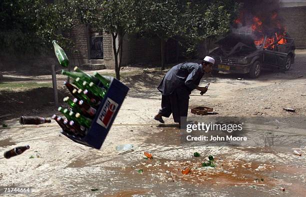 Protesters throw a case of softdrinks during a violent demonstrationAugust 29, 2006 in Quetta, Pakistan. More than a thousand angry Baloch took to...