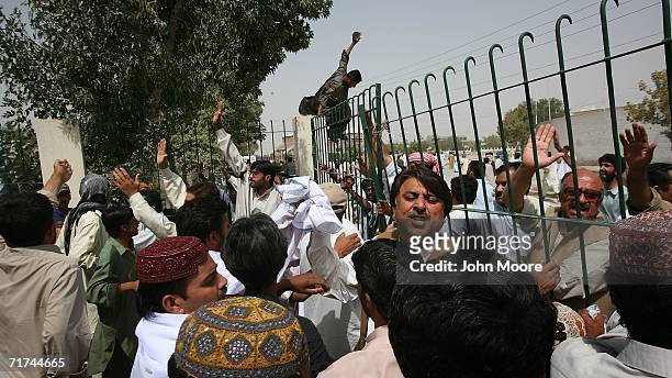 Protesters try to push down a gate during a violent demonstration August 29, 2006 in Quetta, Pakistan. More than a thousand angry Baloch took to the...