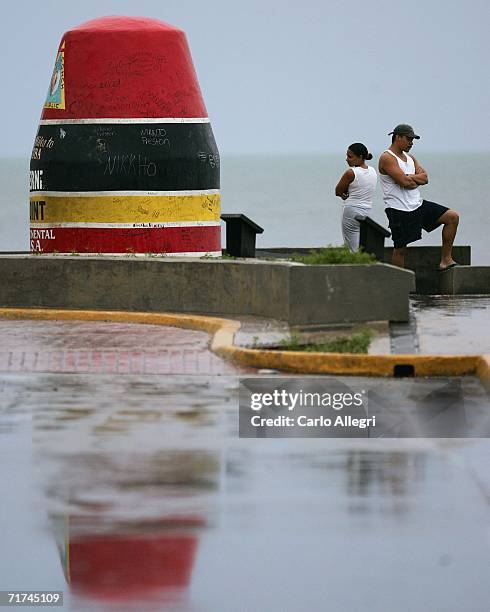 Couple looks out over the water at the Southern most point of the U.S. As the rains begin in advance of Tropical Storm Ernesto August 29, 2006 in Key...