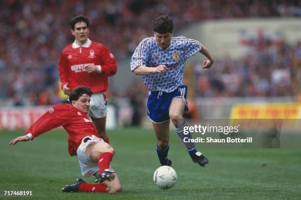 Dennis Irwin of Manchester Utd holds onto the ball from the Nottingham Forest defender Gary Crosby as Nigel Clough looks on during their Rumbelows...