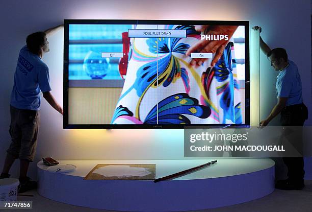 Technicians install a 100-inch LCD TV with ambilight at Dutch electronics giant Philips' stand at Berlin's IFA Consumer Electronics trade fair 30...