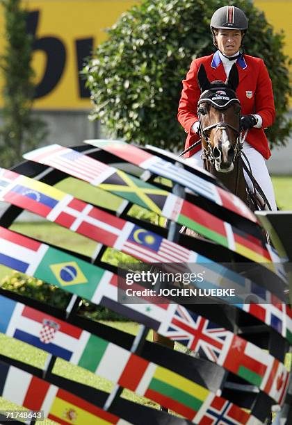 Rider Beezie Madden on "Authentic" rides past globe-shaped flags during the first round of the jumping competition of the World Equestrian Games in...