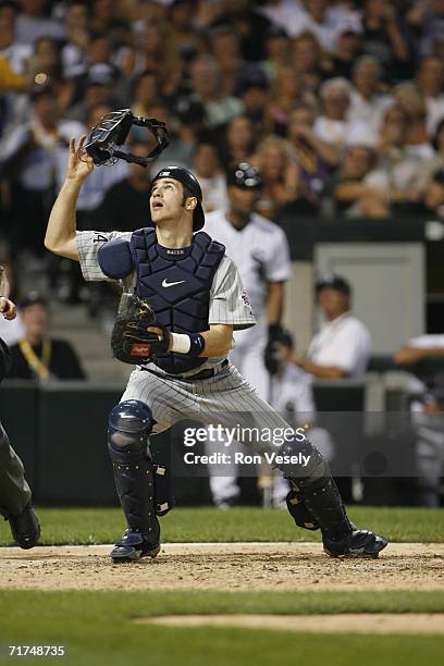 Joe Mauer of the Minnesota Twins attempts to catch a foul ball while catching during the game against the Chicago White Sox at U.S. Cellular Field in...