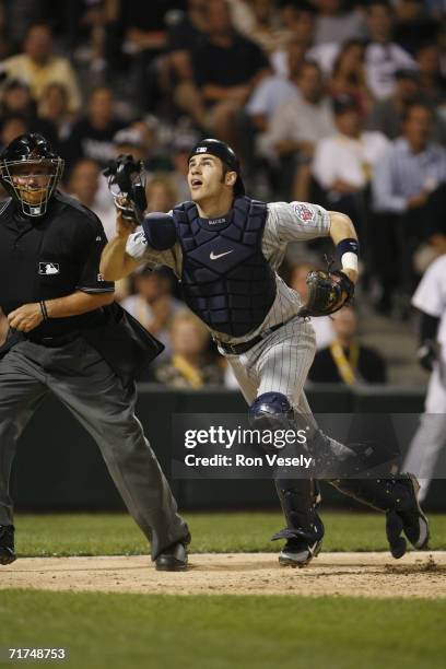 Joe Mauer of the Minnesota Twins attempts to catch a foul ball while catching during the game against the Chicago White Sox at U.S. Cellular Field in...