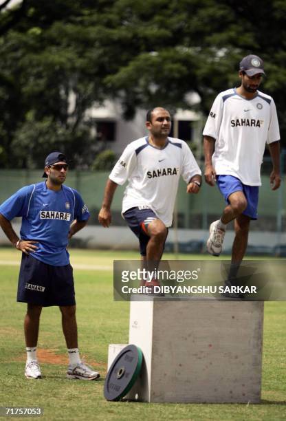 Indian cricketers Yuvraj Singh Virender Sehwag and Mohammed Kaif stretch during a practice session at The National Cricket Academy in Bangalore, 31...