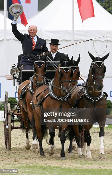 Michael Freund of Germany and his co-drivers compete in the Four-in-Hand Driving dressage competition of the World Equestrian Games in Aachen 31...