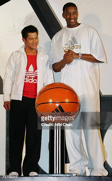 Player Tracy McGrady of the Houston Rockets and Hong Kong singer-actor Aaron Kwok attend the grand opening ceremony of Adidas Sport Performance...