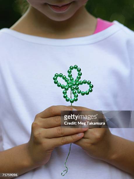 close-up of a girl holding an artificial cloverleaf - fake of indian girls stock pictures, royalty-free photos & images