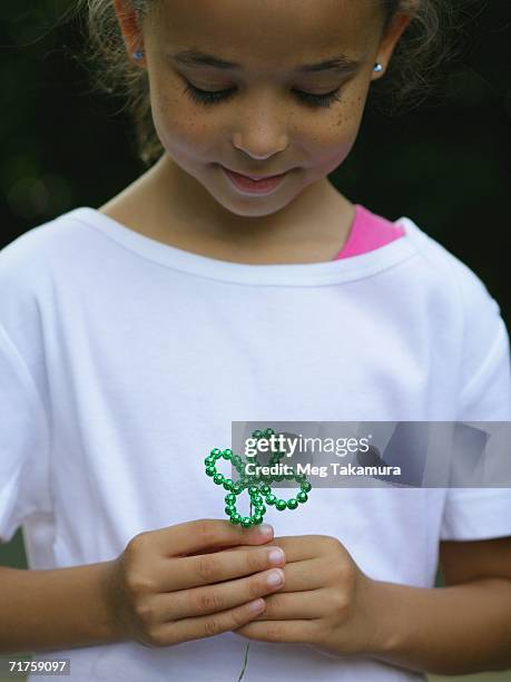 close-up of a girl holding an artificial cloverleaf - fake of indian girls stock pictures, royalty-free photos & images