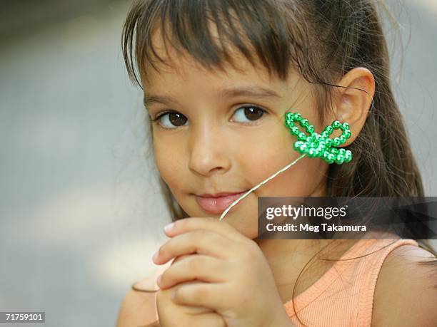 portrait of a girl holding an artificial cloverleaf - fake of indian girls stock pictures, royalty-free photos & images