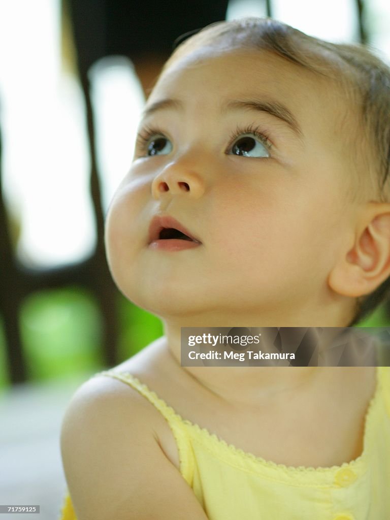 Close-up of a baby girl looking up