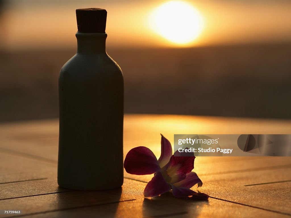 Close-up of a massage oil bottle with a flower (Orchid)
