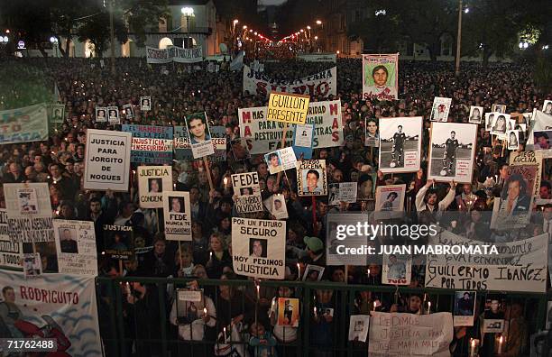 Buenos Aires, ARGENTINA: Familiares de victimas de la violencia muestran fotos y carteles en la Plaza de Mayo de Buenos Aires, durante un acto...