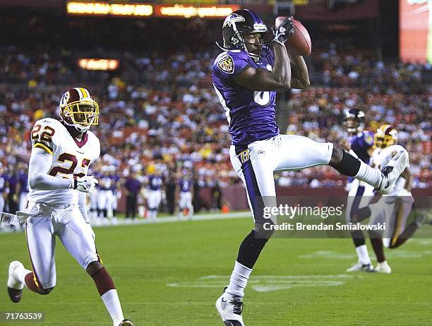 Washington Redskins Carlos Rogers watches as Baltimore Ravens Mark Clayton catches a pass in the Washington Redskins end zone to score the first...