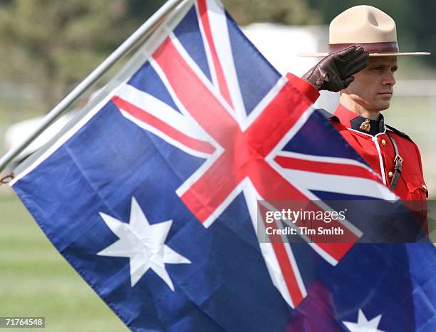 Royal Canadian Mounted Police officer salutes behind the flag of Australia as the national anthems of Team Australia and Team South Africa play...