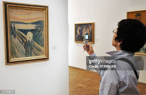 Japanese tourist takes a snap of a copy of Edvard Munch's expressionist masterpiece "The Scream", 01 September 2006 in the Munch Museum in Oslo....