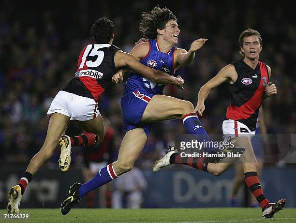 Ryan Griffin for the Bulldogs kicks clear of Courtenay Dempsey for Essendon during the round 22 AFL match between the Western Bulldogs and the...