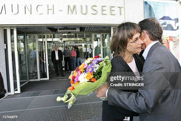 The acting Munch Museum chief Ingebjoerg Ydstie gets flowers, hug, and congratulations from the leader of Oslo's City Council, Erling Lae, outside...