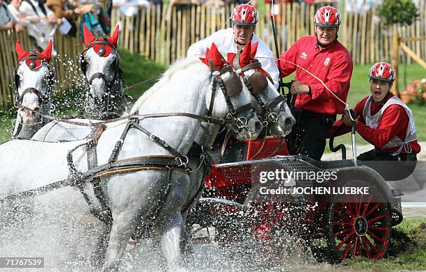 Ole Buch Jensen and his co-drivers of Denmark take part in the Four-in-Hand Driving marathon competition of the World Equestrian Games in Aachen 01...