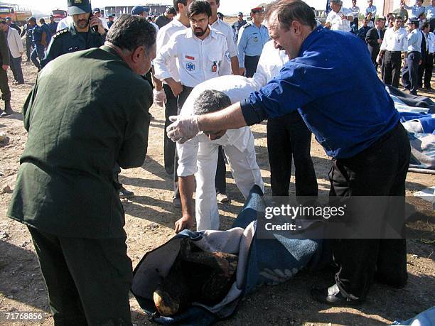 Rescue workers cover the body of a victim with a blanket after an Iranian airliner caught fire on landing in the northeastern city of Mashhad 01...