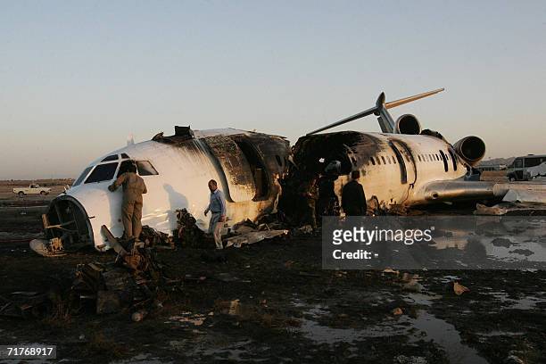 Iranians search the wreckage of an Iranian airliner which caught fire on landing at the Hasheminejad airport in the city of Mashhad, 900 kms...