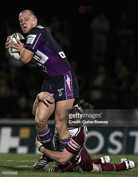 Scott Hill of the Storm tries to break through a tackle by Steve Menzies of the Sea Eagles during the round 26 NRL match between the Melbourne Storm...