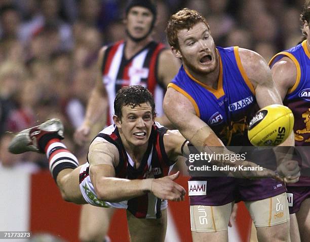 Daniel Merrett of the Lions is pressured by Luke Ball of the Saints during the round 22 AFL match between the Brisbane Lions and the St.Kilda Saints...